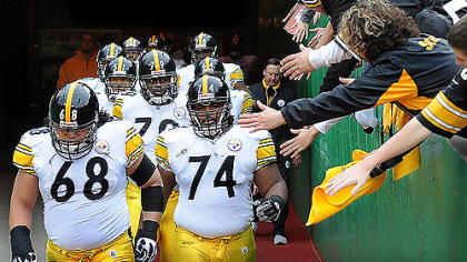 Steelers offensive linemen Chris Kemoeatu, left, and Willie Colon head past fans as they make their way to the field with the rest of their teammates yesterday in Kansas City.