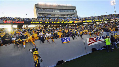 West Virginia's Kent Richardson, left, celebrates with fans following a 17-9  win against Louisville yesterday in Morgantown.