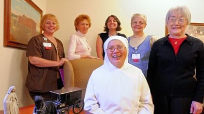 Those traveling to Rome for the ceremony from the Little Sisters of the Poor in Pittsburgh's Brighton Heights neighborhood include Sister Rosemarie Yao, seated, and standing, from left, Cathy Jo McConnell, Lee Comport, Kathleen Baker, Valerie Beam and Machiko Seto. On the table is a replica of the order's horse wagon that used to ply Pittsburgh streets.