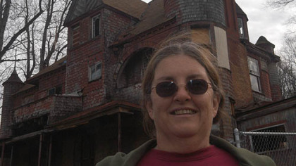 Brenda Kalwasinski, president of the Cresson Area Historical Society, stands in front of the house.