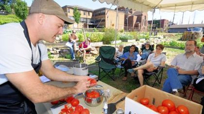 Jamie Moore, Eat'n Park's director of sourcing and sustainability, demonstrates canning tomatoes at the Braddock Community Garden last month.