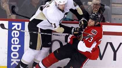 Senators forward Jakko Ruutu is checked by Penguins defenseman Martin Skoula during the first period.