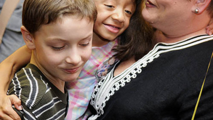 Lexie Jae Bouchard, 9, gets a hug from her brother Alex, 11, and her mom, Carol, after officially being adopted in a hearing yesterday in Allegheny County Family Court on National Adoption Day.