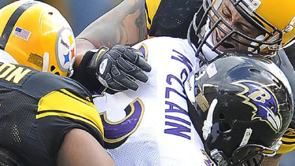 Steelers linebacker laMarr Woodley, right, and defensive lineman Casey Hampton tackle Ravens running back Le'Ron McClain during yesterday's 23-20 win at Heinz Field.