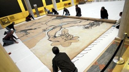 Staff at the Carnegie Museum of Art roll up Dali's 1942 curtain "Theseus Minotaur" after inspecting it yesterday.
