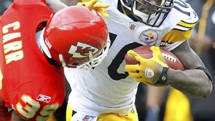 Steelers Santonio Holmes fights off a tackle by Chiefs defensive back Brandon Carr.