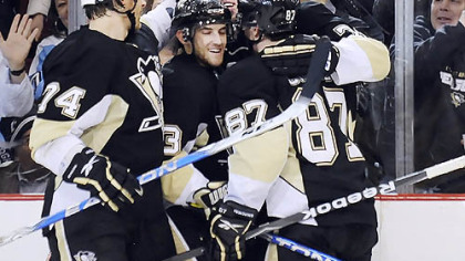 Jay McKee (74), Alex Goligoski (3) and Sidney Crosby (87) celebrate with Evgeni Malkin after Malkin's third goal.
