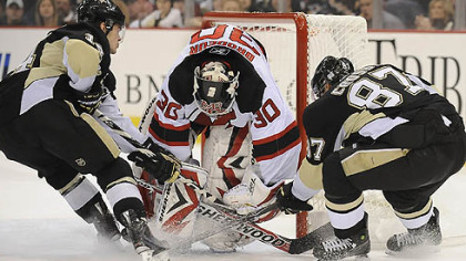 Chris Kunitz and Sidney Crosby try to push the puck past Devils goalie Martin Brodeur in Saturday's loss.