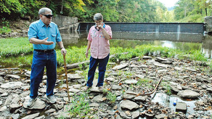 Verna Presley covers her nose to block out the smell of rotting fish as she walks along Dunkard Creek with her husband, Ed, on their property near the village of Brave in Greene County. So far, 161 species of fish, mussels, salamanders, crayfish and aquatic insects have been wiped out along the creek.