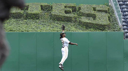 Pirates outfielder Andrew McCutchen leaps to catch a ball in center field.