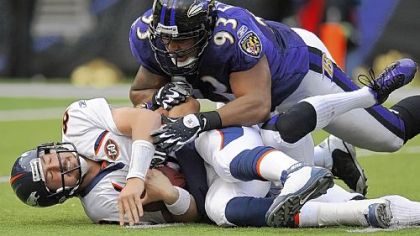 Broncos quarterback Kyle Orton lies on the field after being sacked in the fourth quarter by Baltimore Ravens cornerback Chris Carr (partially obscured) and defensive tackle Dwan Edwards during Sunday's game in Baltimore.
