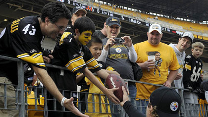 Ethan Kahn, 10, of Chappaqua, NY., receives a football from Steelers quarterback Ben Roethlisberger prior to the Sunday's game.  For Ethan and his father Oren Kahn, left, this is the first time they have been to a Steelers' game.