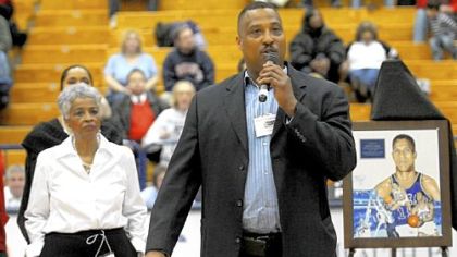 Charles Cooper III speaks to the crowd during halftime at the Palumbo Center -- part of  ceremonies surrounding the Chuck Cooper Classic. Irva L. Cooper, wife of Chuck Cooper, watches.