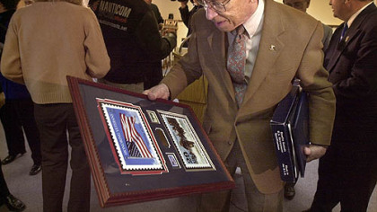 Jack Foley, a member of "Easy Company," looks at his plaque and holds a U.S. flag following ceremonies in the Penn Hills Muncipal Building in 2001.