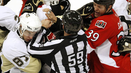 Penguins forward Sidney Crosby throws a punch at Senators defenseman Matt Carkner during.