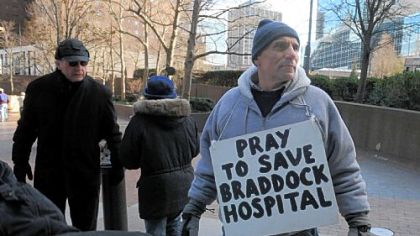 Pat Minnaji, of East Pittsburgh, wears his protest sign after the prayer vigil to save UPMC Braddock hospital ends on Grant Street near the U.S. Steel Tower in Downtown Pittsburgh.