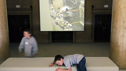 Cao Fei's video "Whose Utopia," part of the 2008 Carnegie International, "Life on Mars," is projected into an unused museum entryway that these children play in front of at the Carnegie Museum.